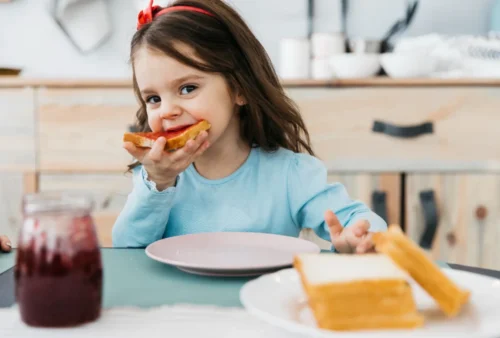 A young girl eats her breakfast